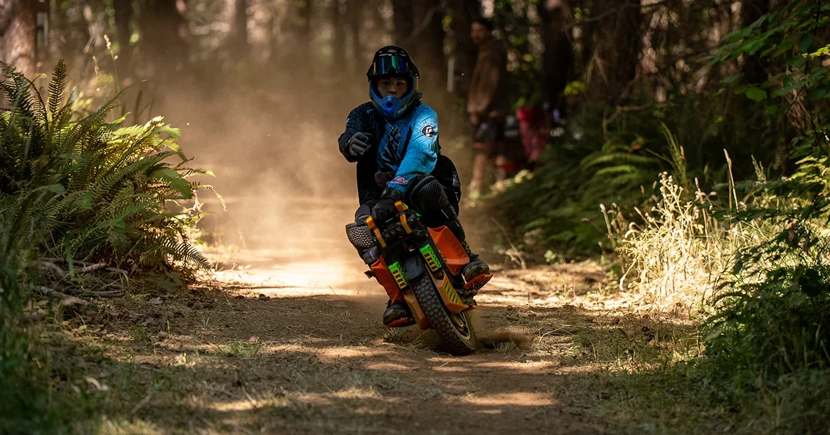 Electric unicycle racer Kyler Brown on narrow forest singletrack at Northwest Electric Fest 2026 in Veneta, Oregon
