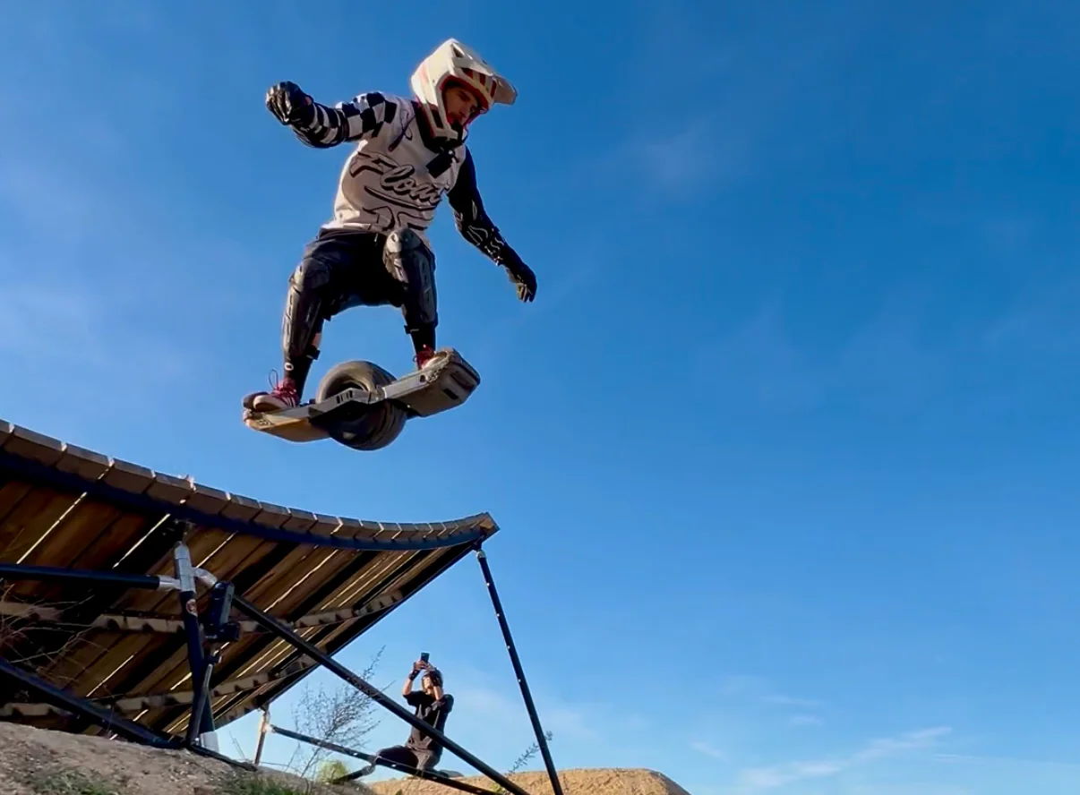 Cameron Patecell airborne on a Onewheel at a bike park